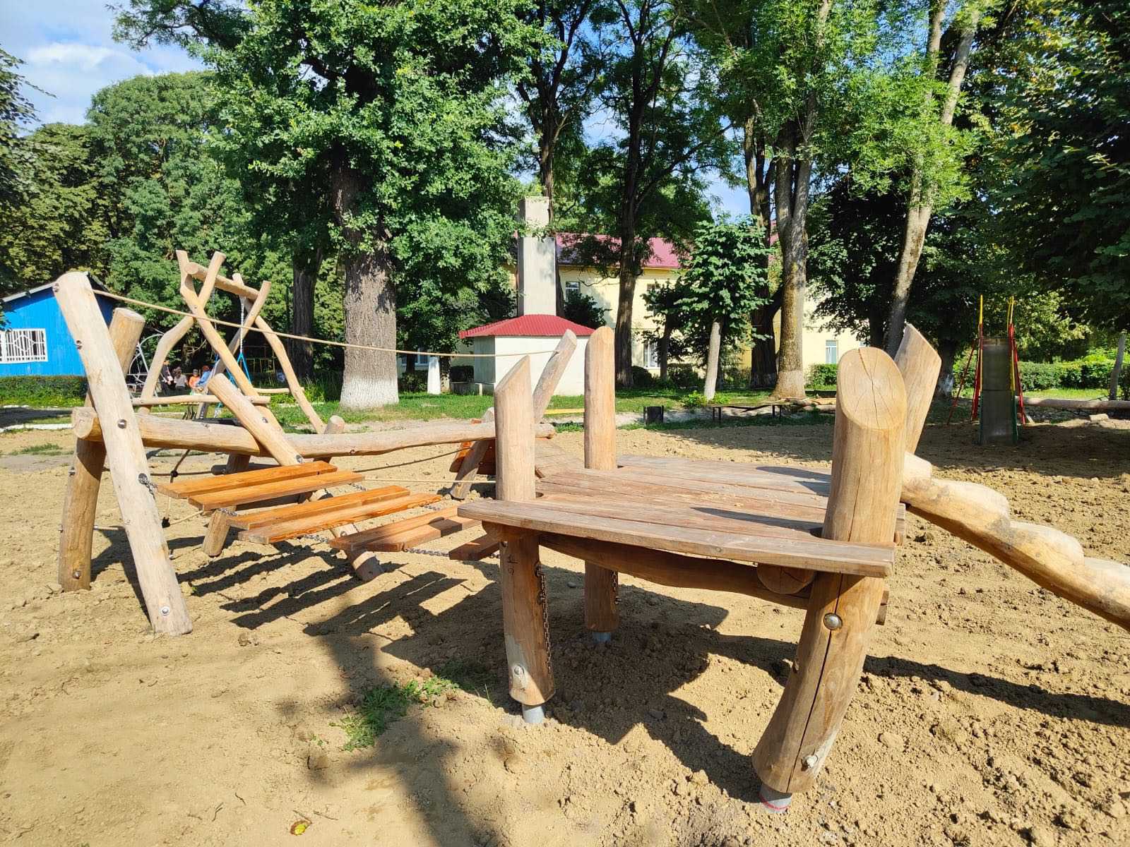 Holzspielplatz im Park bei sonnigem Wetter